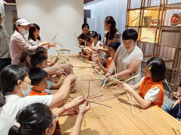 山東手造展示體驗(yàn)中心，博興草編傳承人張慧華帶孩子們體驗(yàn)草編技藝